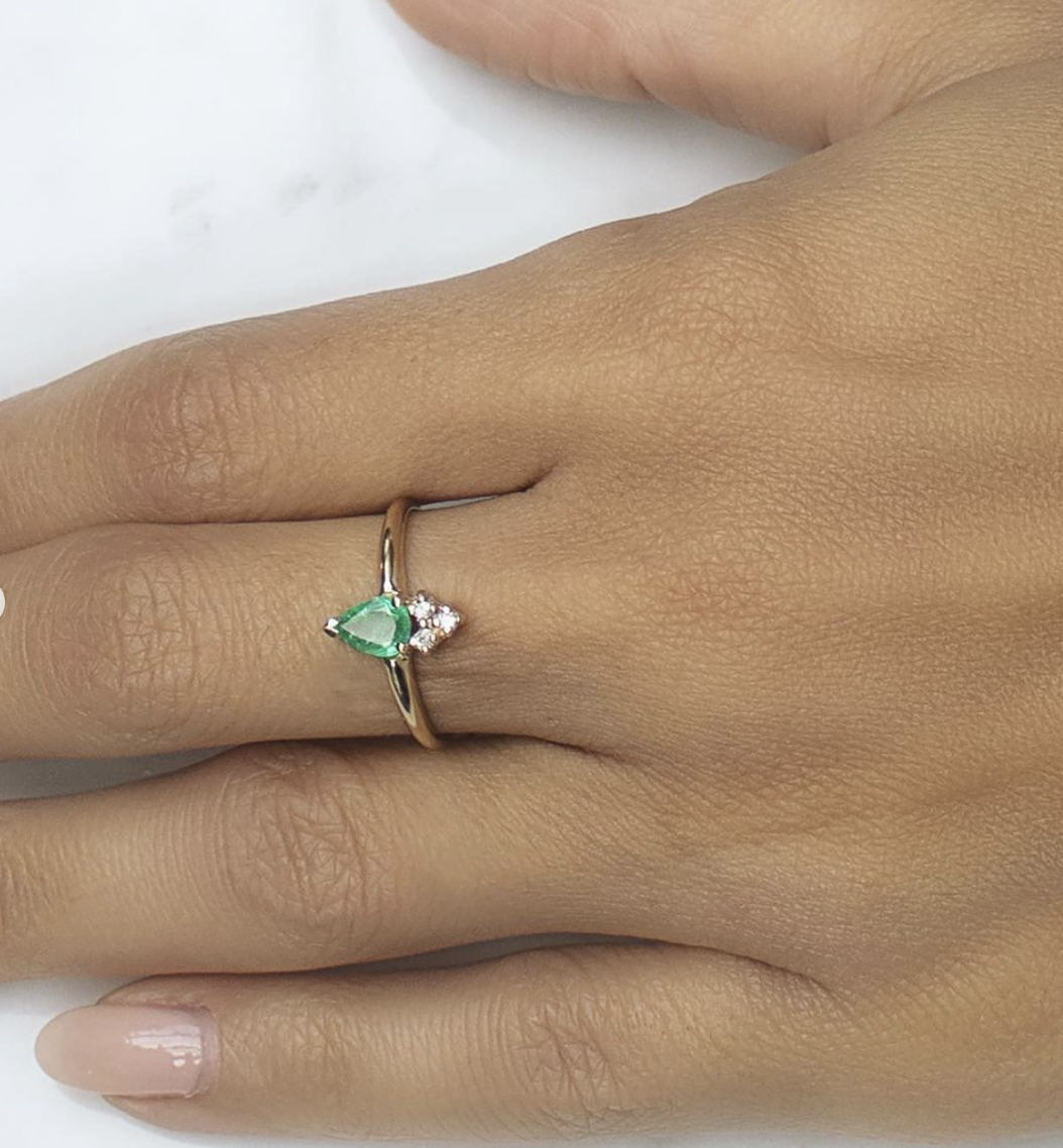 Close up view of the Venus 14K Gold Emerald Pear Ring with Diamonds on a model's hand