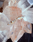 14K yellow gold tapered baguette diamond stud earrings on a quartz display by Camille Jewelry