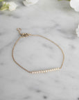 Diamond Bar Bracelet – 14K Gold Pavé Fine Jewelry on a quartz display- Camille Jewelry