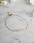 Diamond Bar Bracelet – 14K Gold Pavé Fine Jewelry on a quartz display- Camille Jewelry
