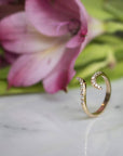 Diamond and Gold Pinky Ring for Women on display with a flower in background by Camille Jewelry.