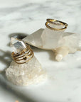 Gold filled textured and solid wire rings with bezel CZ and heart details on quartz display by Camille Jewelry.