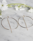 Gold Filled Threader Hoop Earrings on quartz display with white flowers by Camille Jewelry