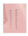 Graduated Diamond Dangle Earrings in 14K White Gold On pink background - Camille Jewelry