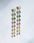 Graduated Rainbow Gemstone Dangle Earrings in 14K gold on a gray background: Camille Jewelry
