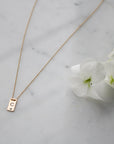 14K gold filled Mini Plaque Personalized Necklace on a quartz background- Camille Jewelry