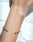 Open Cuff Bracelet | Pear-Shaped Diamond Bangle in 14K Yellow Gold on models arm- Camille Jewelry