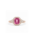 An emerald-cut pink sapphire ring in rose gold, surrounded by a halo of small clear stones and a three-stone diamond band, shown on a plain white background.