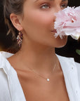 Model wearing rainbow tourmaline cluster gold earrings while holding a flower- Camille Jewelry
