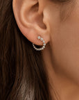small diamond hoop earrings in 14K yellow gold on close up of models ear by camille Jewelry.