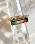 14K gold tourmaline gemstone ring in watermelon tourmaline in a diamond bar design on a quartz display by Camille Jewelry