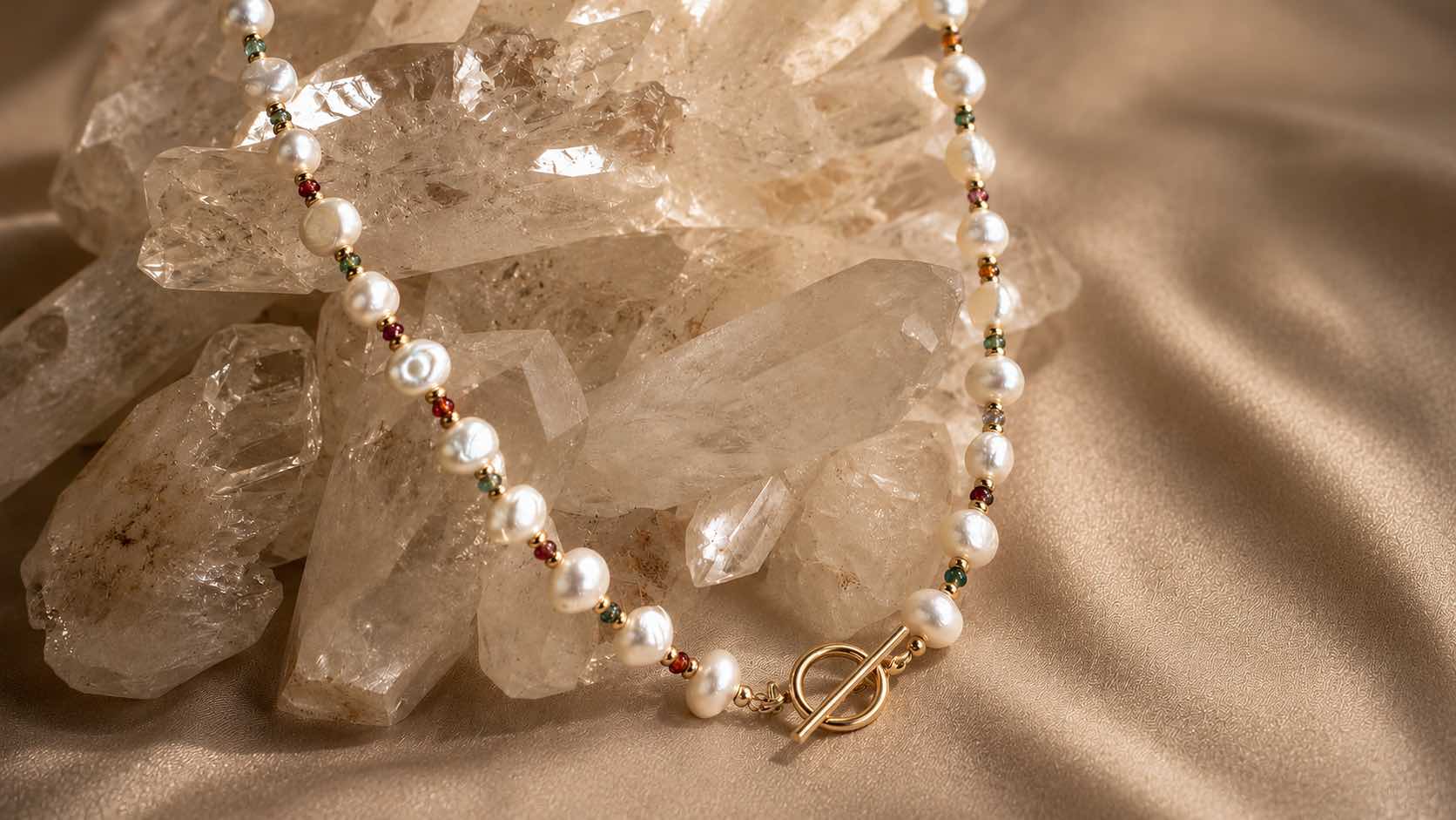 Gemstone necklaces in freshwater pearl and tourmaline on a quartz display for Camille Jewelry