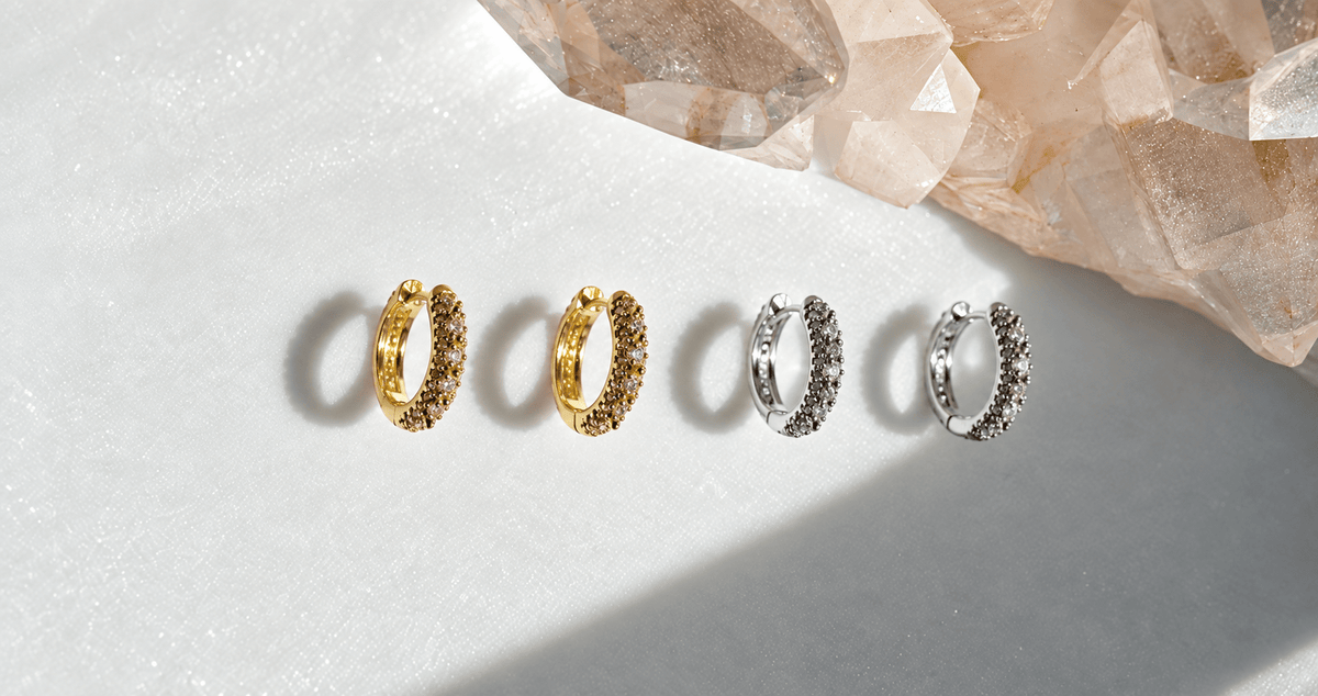 gold and silver earrings on a white background with a quartz display by Camille Jewelry.