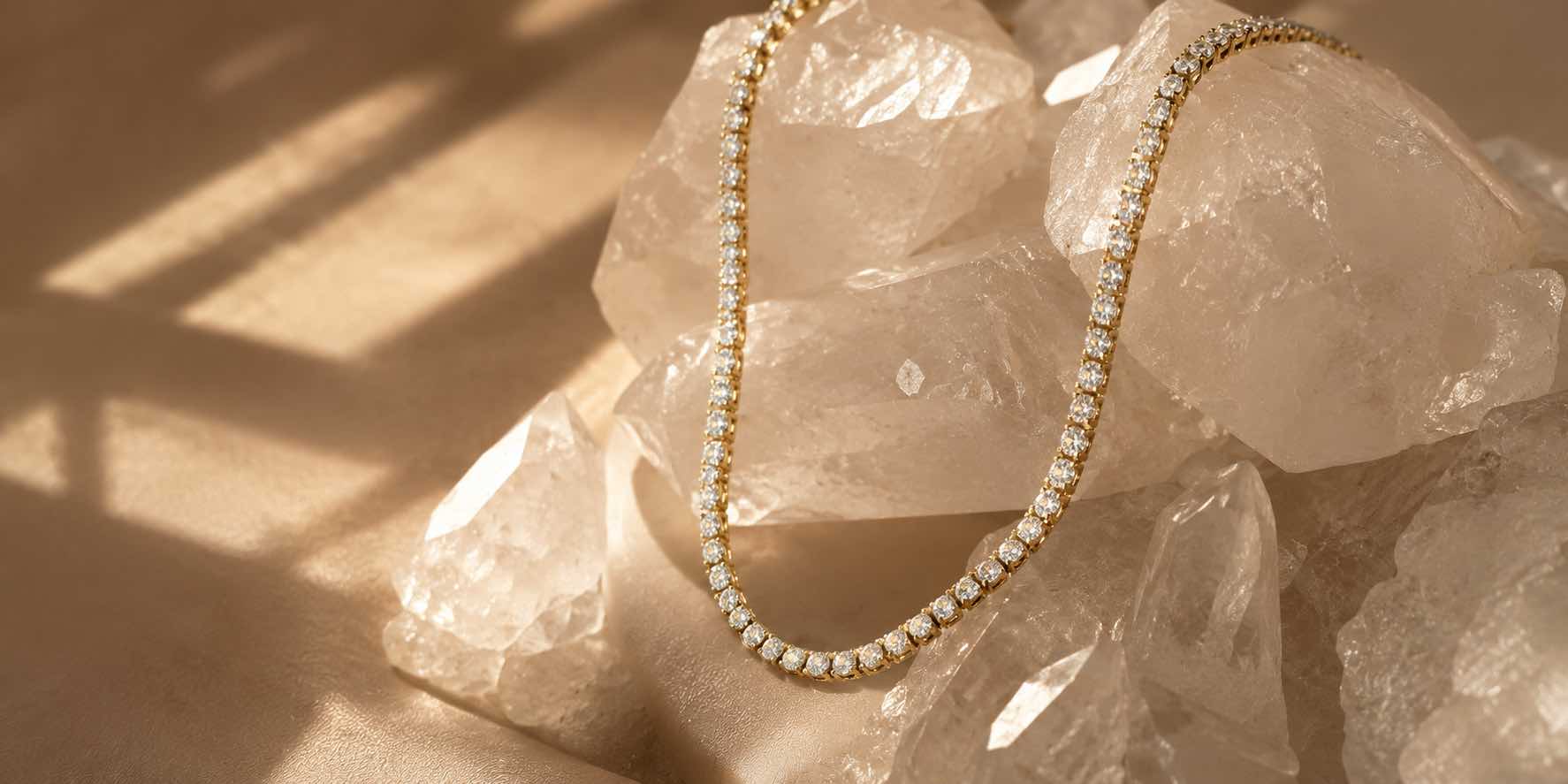 Gold tennis necklace with white stones on blush silk by Camille Jewelry