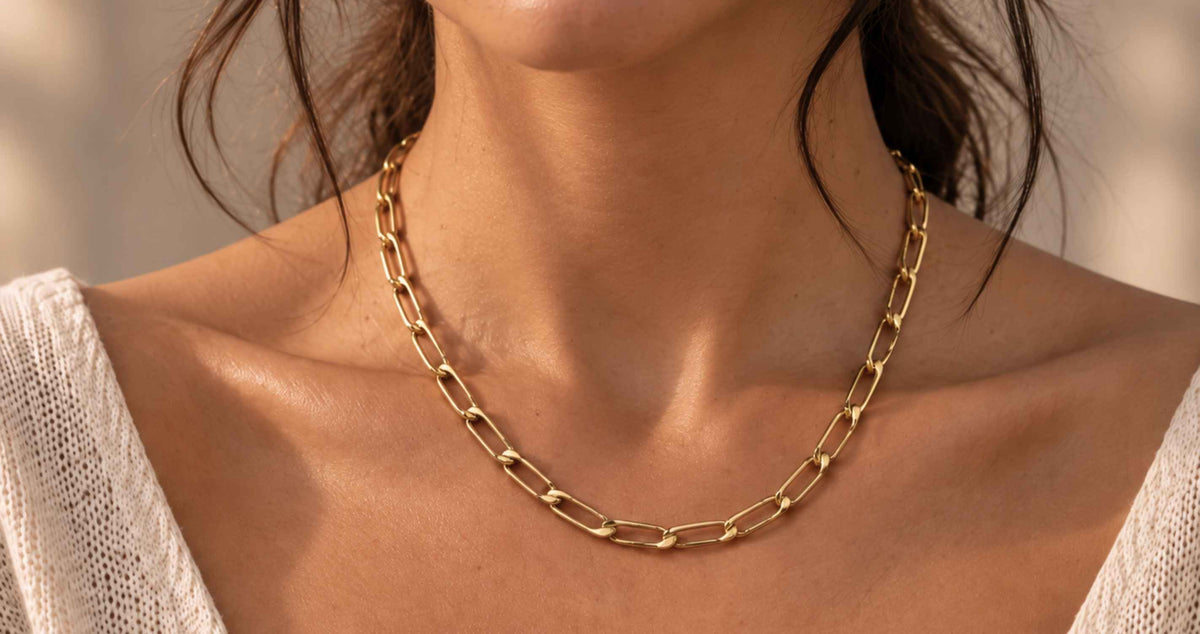 gold filled jewelry on model wearing a elongated curb chain necklace with soft lighting by Camille Jewelry