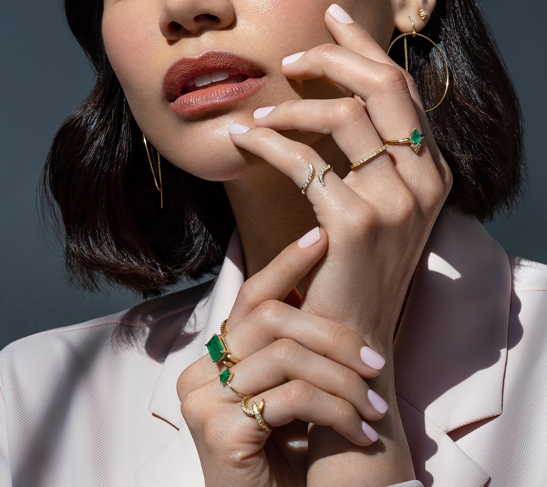 Woman wearing gold, emerald and diamond rings and jewelry | Camille Jewelry