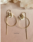 Gold filled threader hoop earrings in fresh water pearl rondelles on a flat view on a pink background. 