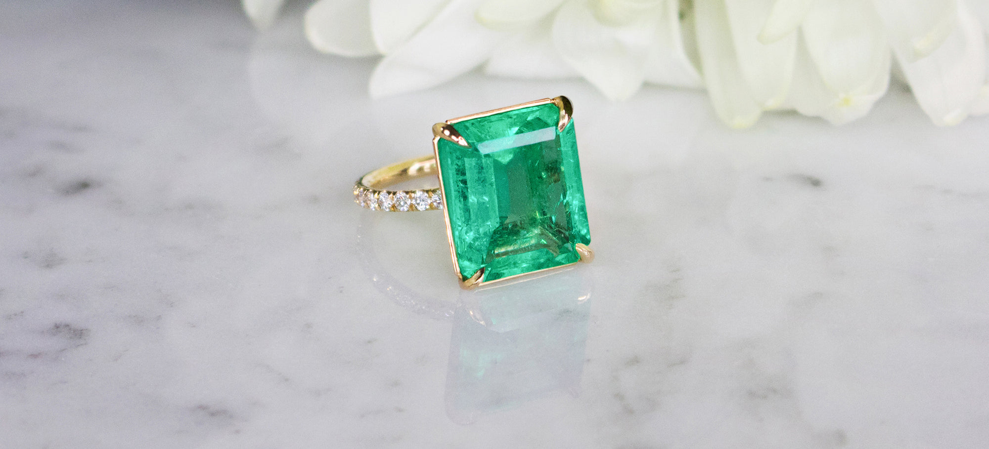 Emerald and diamond ring by Camille Jewelry showcasing fine craftsmanship and setting detail.