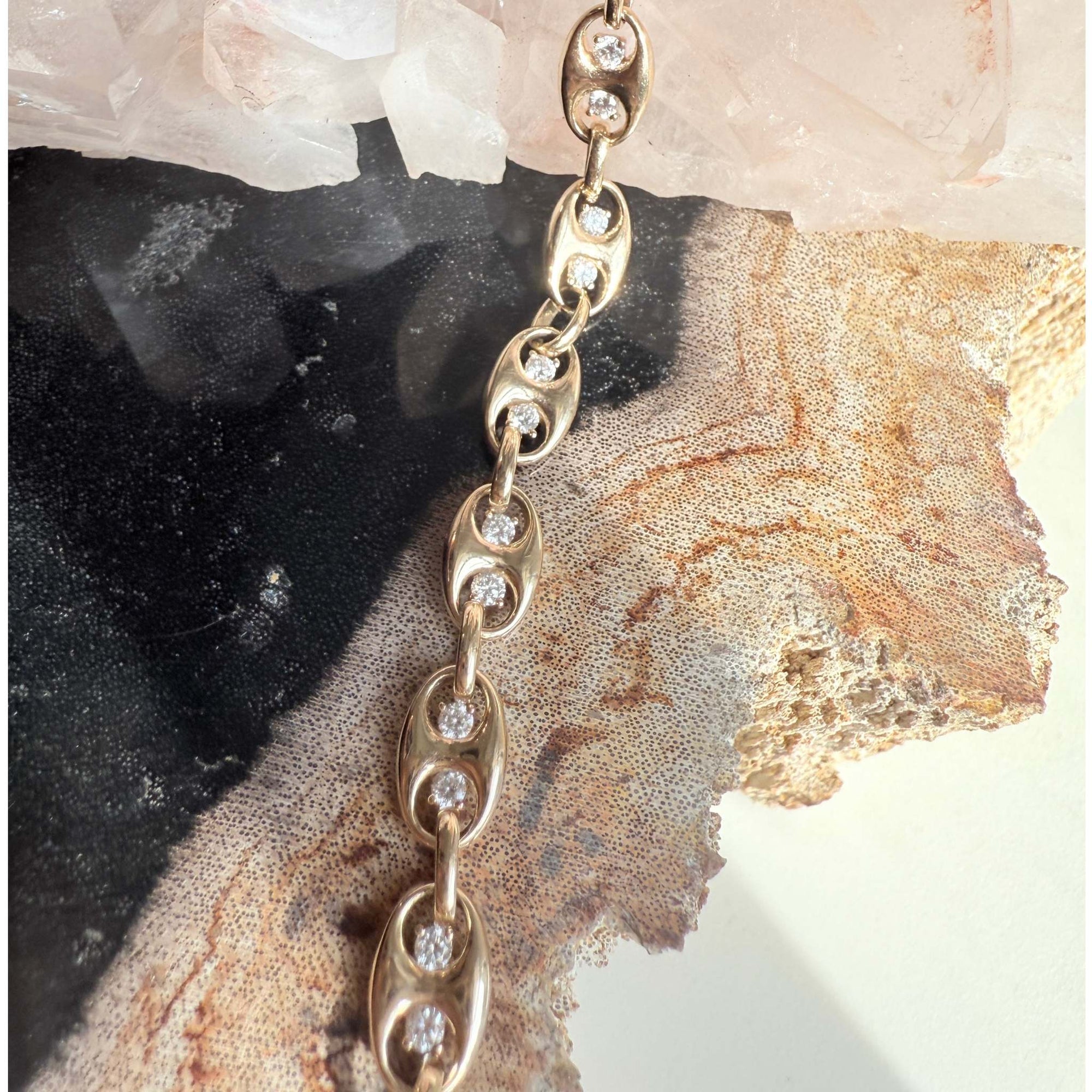Gold mariner bracelet with lab diamond accents on a textured stone background by Camille Jewelry