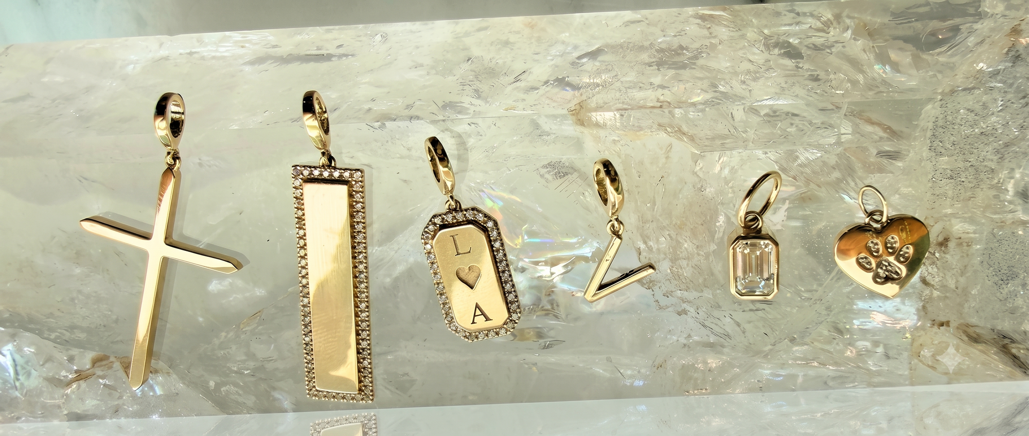Personalized jewelry for women by Camille Jewelry, gold initial and name pieces on a quartz display.