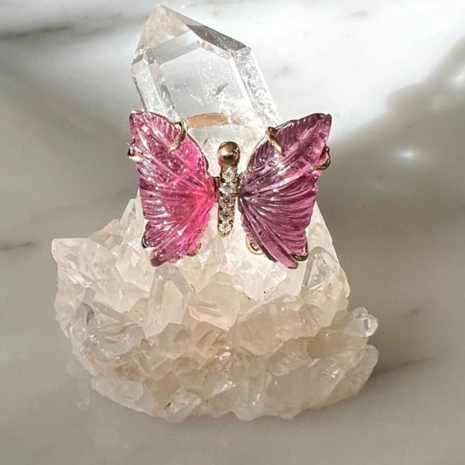 Pink tourmaline butterfly ring with diamonds on quartz stone display | Camille Jewelry