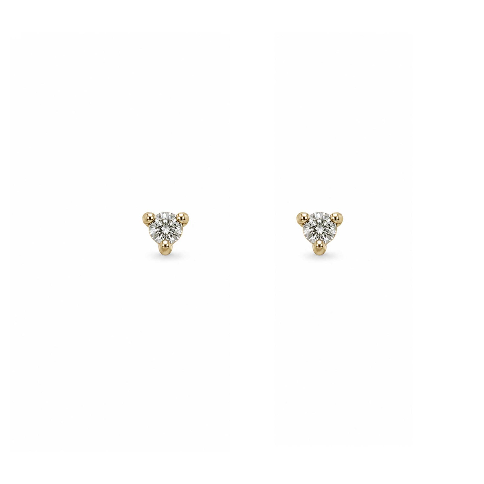 Tiny diamond stud earring in yellow gold worn on model’s ear, Camille Jewelry