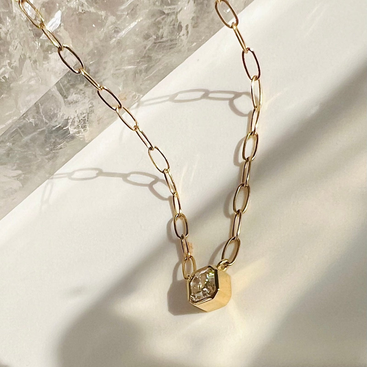 Asscher Cut Moissanite Pendant Necklace in 14K Gold on a quartz background- Camille Jewelry