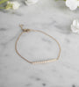 Diamond Bar Bracelet – 14K Gold Pavé Fine Jewelry on a quartz display- Camille Jewelry