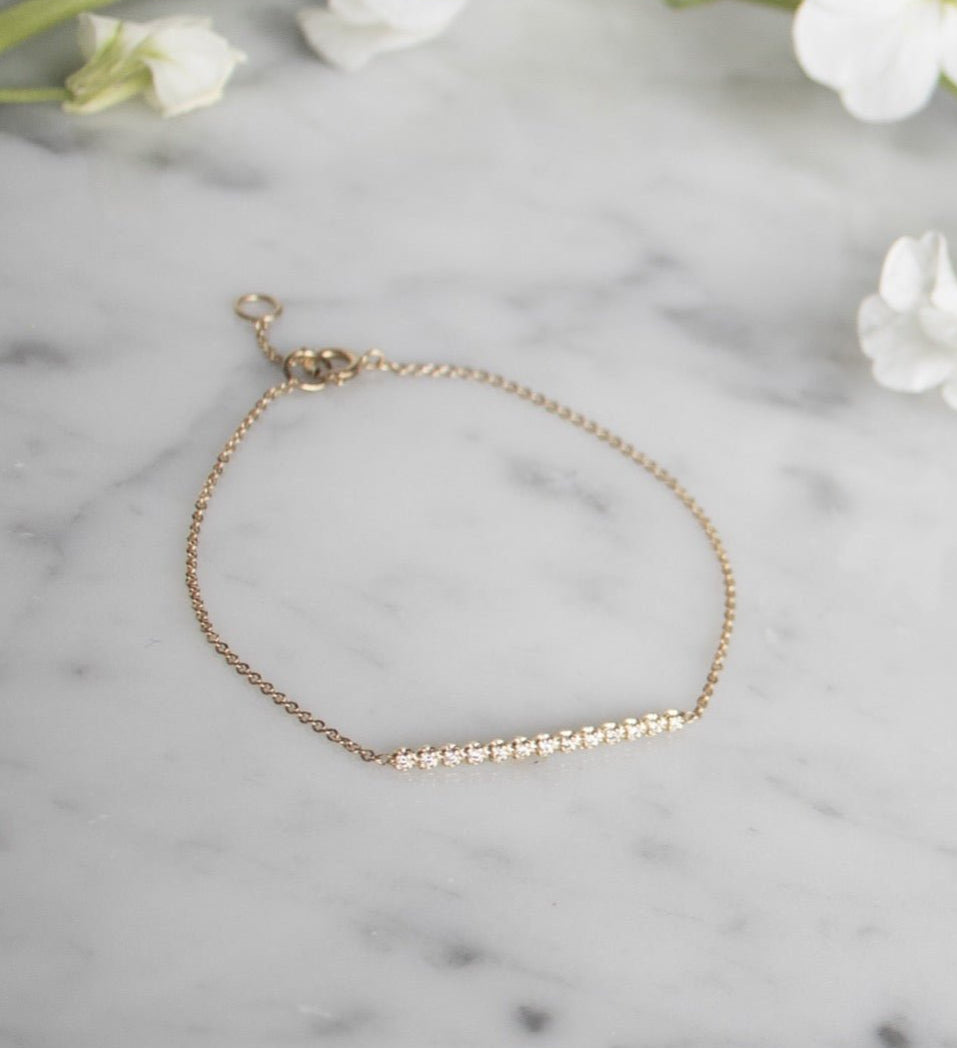 Diamond Bar Bracelet – 14K Gold Pavé Fine Jewelry on a quartz display- Camille Jewelry