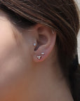 Small Diamond Stud Earrings -14K Yellow Gold Mini Trio Diamonds on models ear- Camille Jewelry