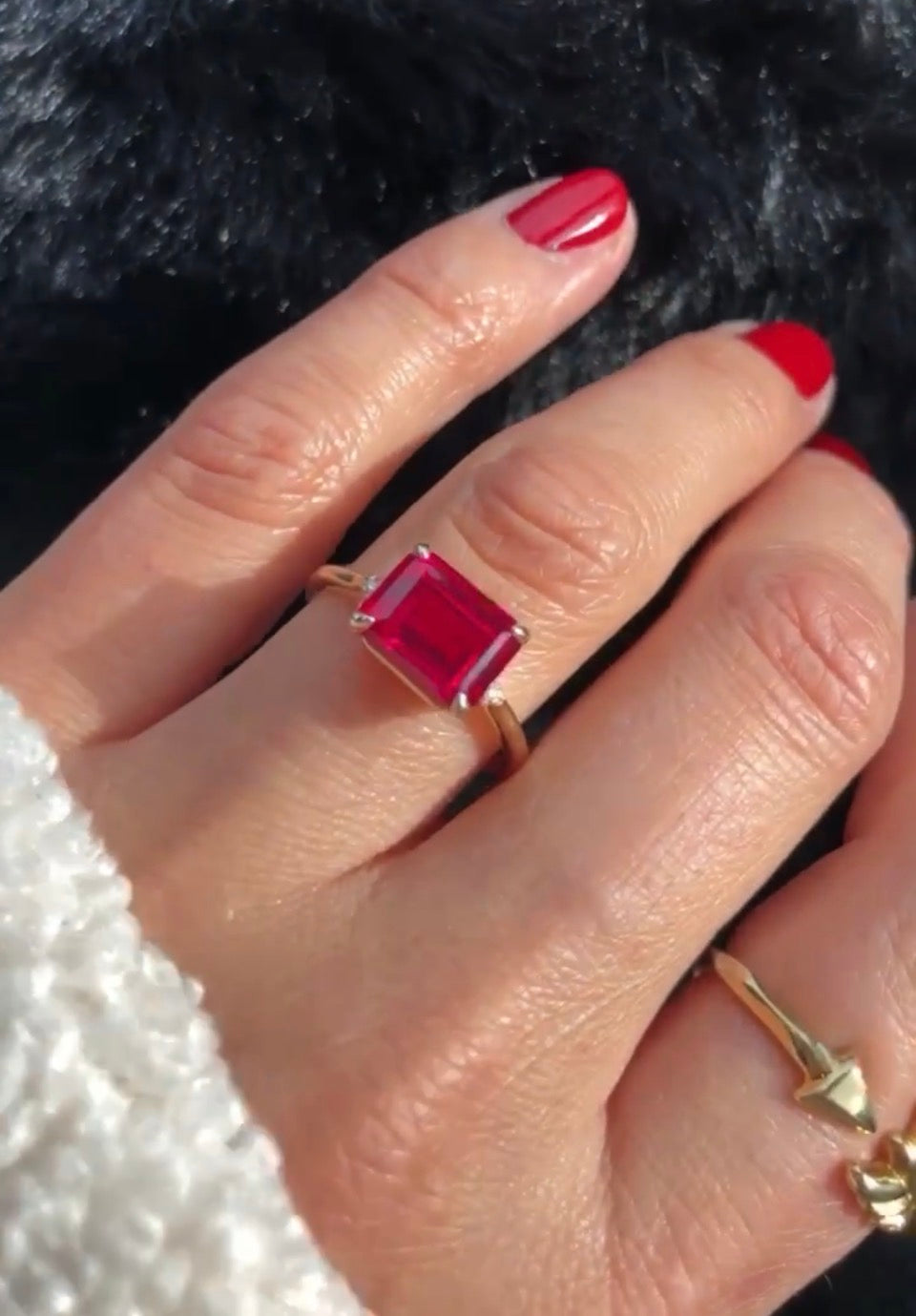 A close up of a emerald cut ruby ring on hand customer review by Camille Jewelry
