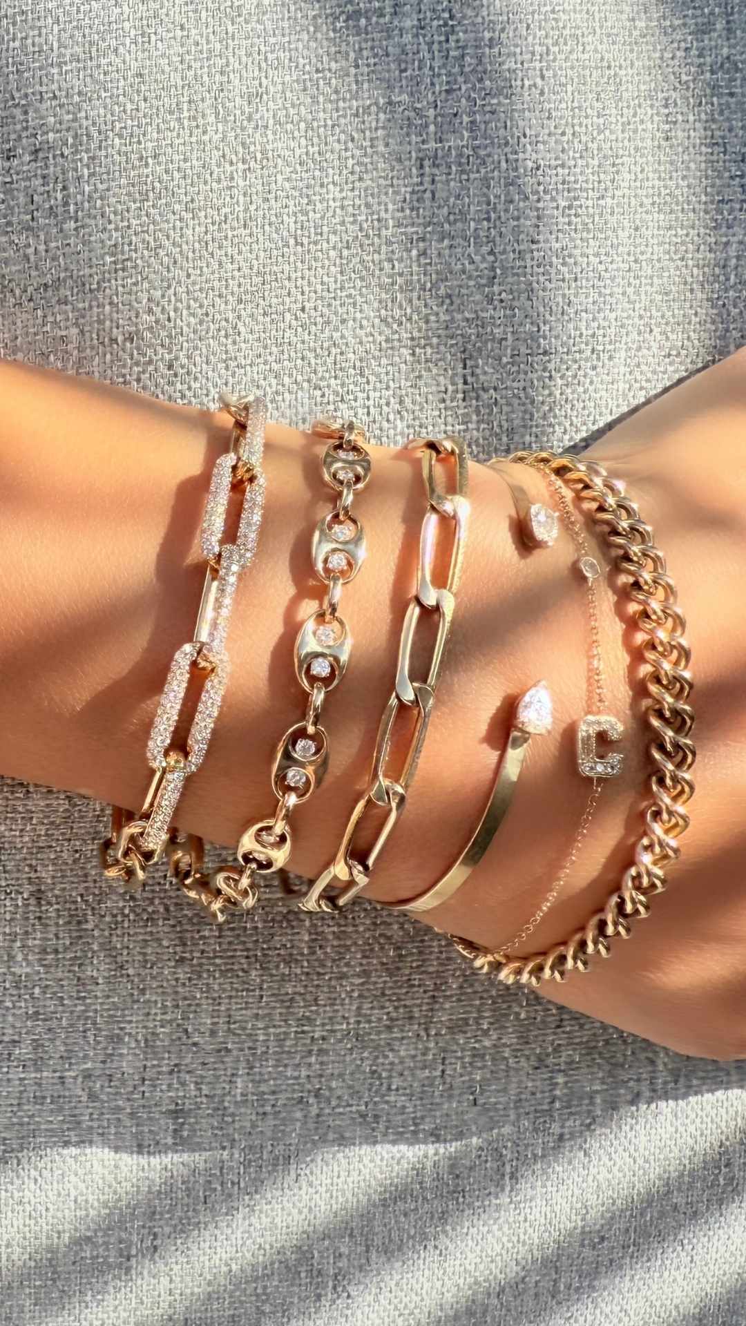 demi fine and fine jewelry stack of gold chain bracelets with diamonds on wrist - Camille Jewelry