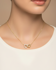 Woman wearing a diamond interlocking heart necklace in 14K gold by Camille Jewelry
