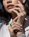 Woman wearing a diamond hook ring in solid 14K yellow gold on her pinky finger by Camille Jewelry

