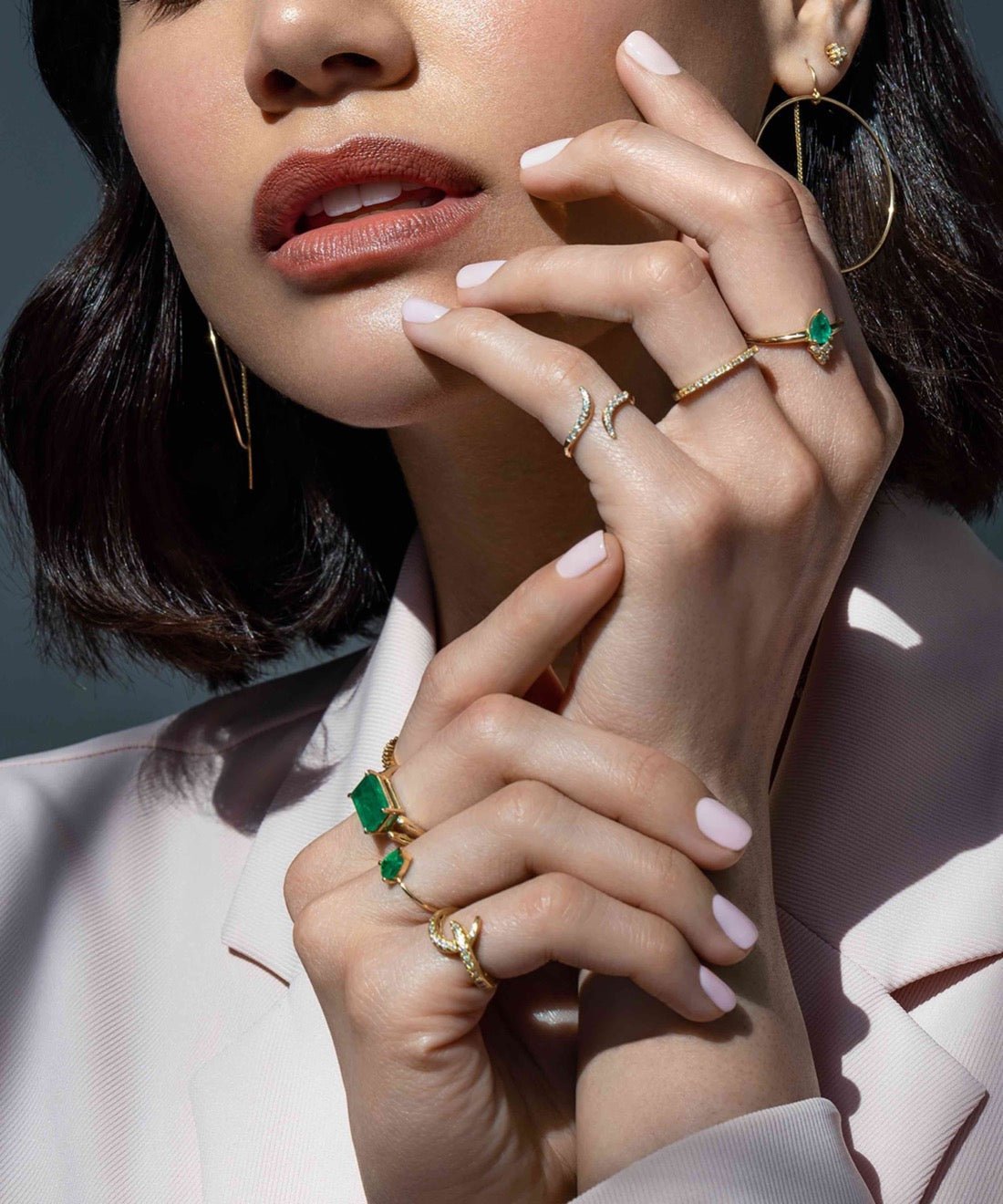 Woman wearing a diamond hook ring in solid 14K yellow gold on her pinky finger by Camille Jewelry
