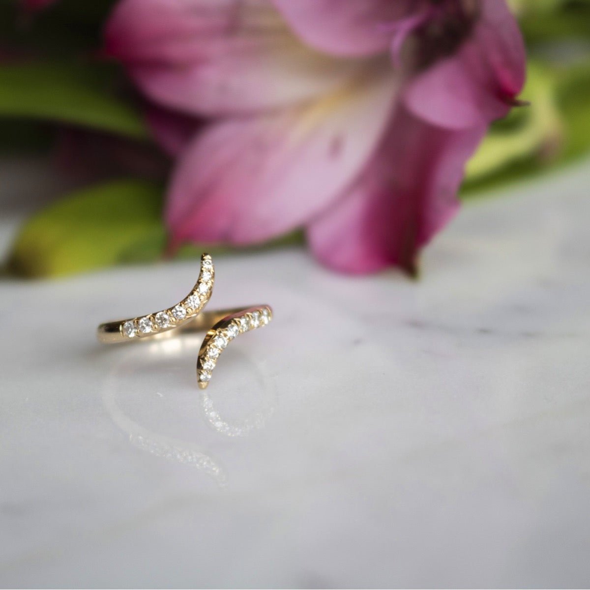 Diamond and Gold Pinky Ring for Women on display with a flower in background - Camille Jewelry