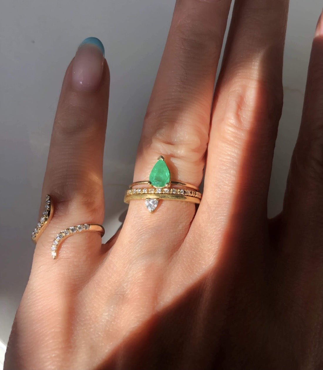 Diamond & Gold Pinky Ring for Women on hand model wearing other emerald and diamond ring stacks by Camille Jewelry.