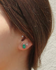 14K yellow gold Emerald Stud Earrings with diamond accent on models ear by Camille Jewelry