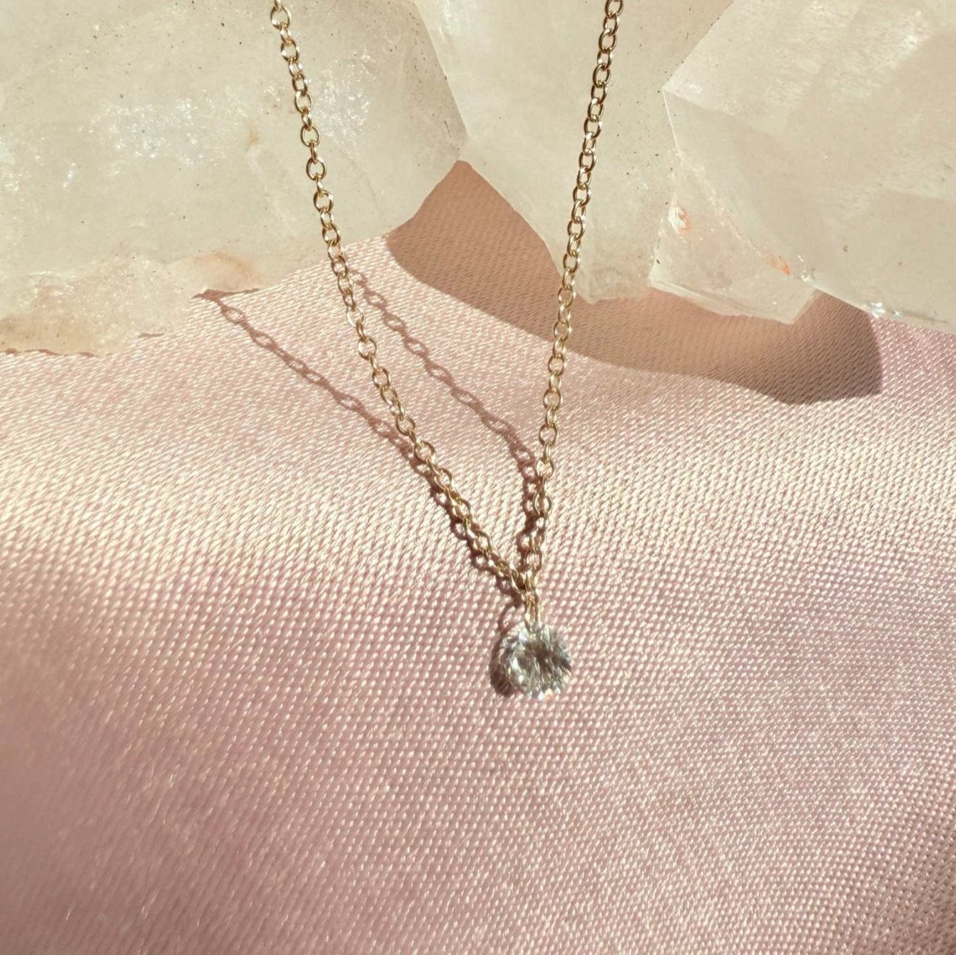 Woman wearing a floating diamond necklace in solid 14K yellow gold by Camille Jewelry