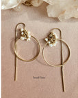 Gold filled threader hoop earrings in fresh water pearl rondelles on a flat view on a pink background. 