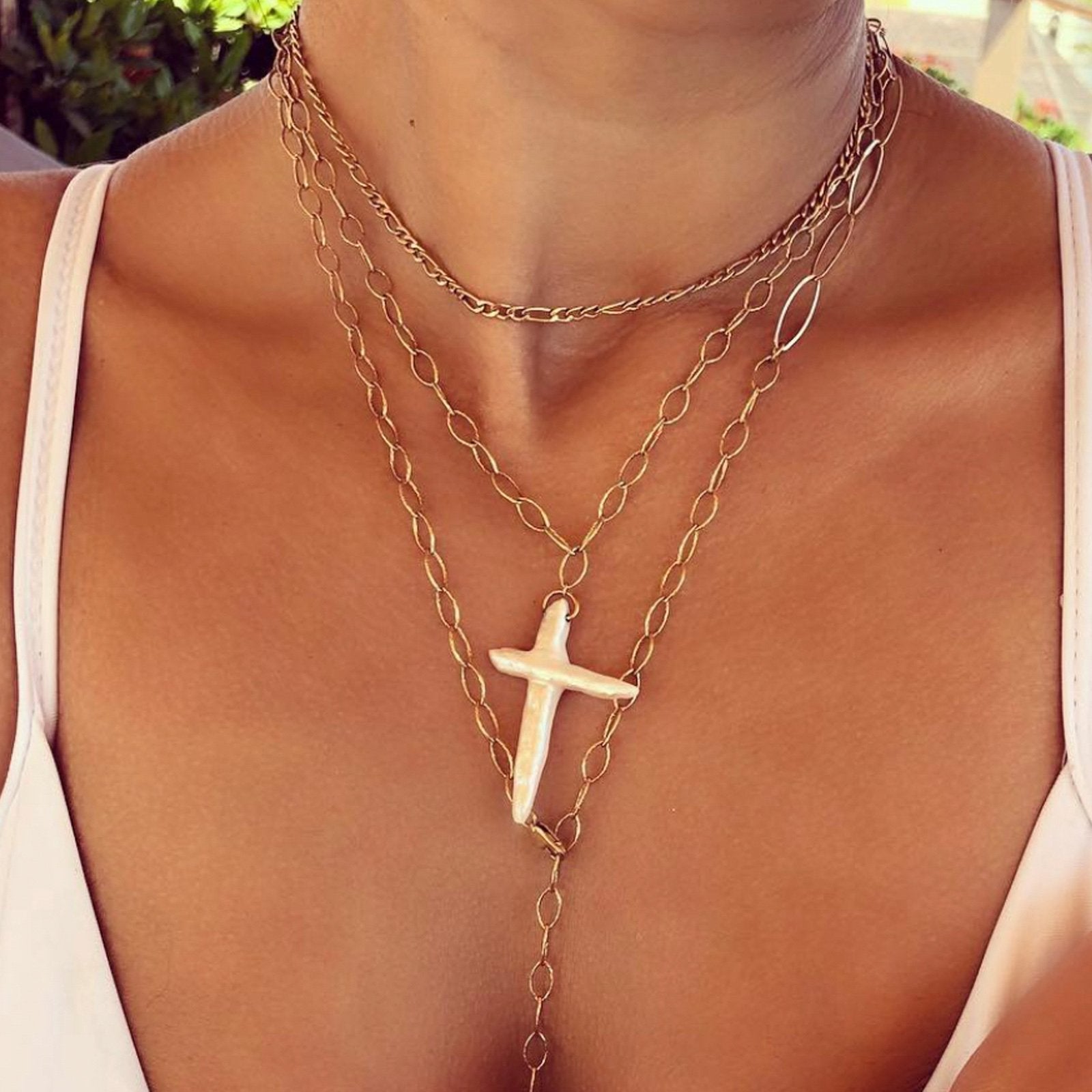 Woman wearing a gold Figaro necklace in 14K gold filled by Camille Jewelry