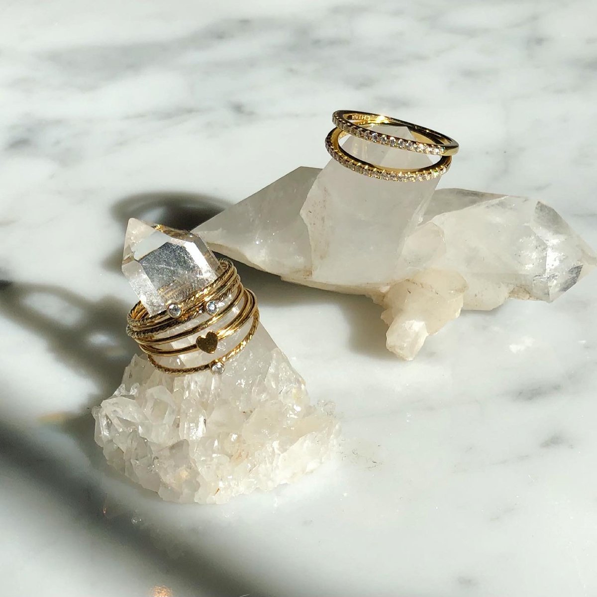 Gold filled textured and solid wire rings with bezel CZ and heart details on quartz display by Camille Jewelry.