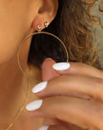 Close-up of a person wearing gold hoop stud earrings and a gold necklace by Camille Jewelry