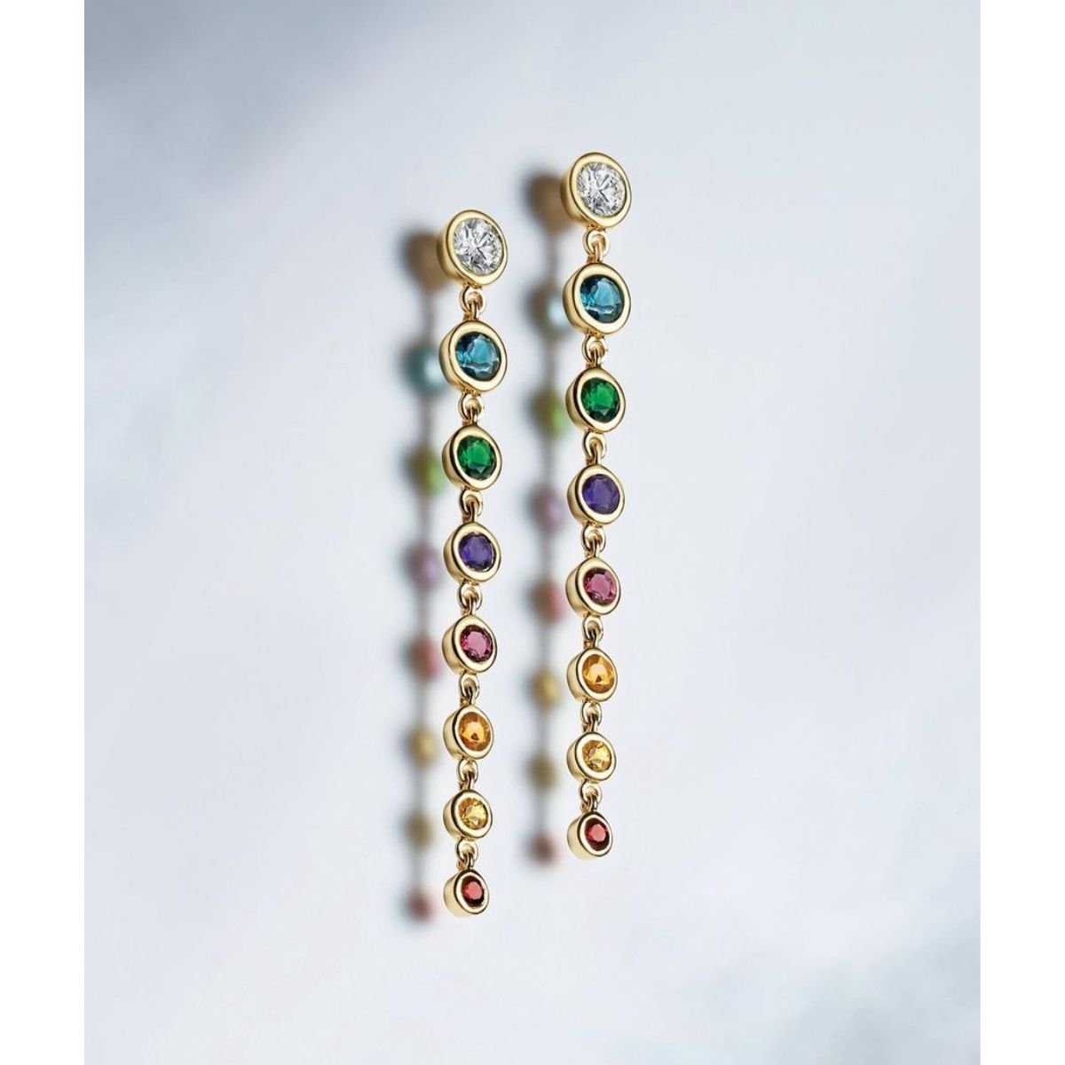 Graduated Rainbow Gemstone Dangle Earrings in 14K gold on a gray background: Camille Jewelry