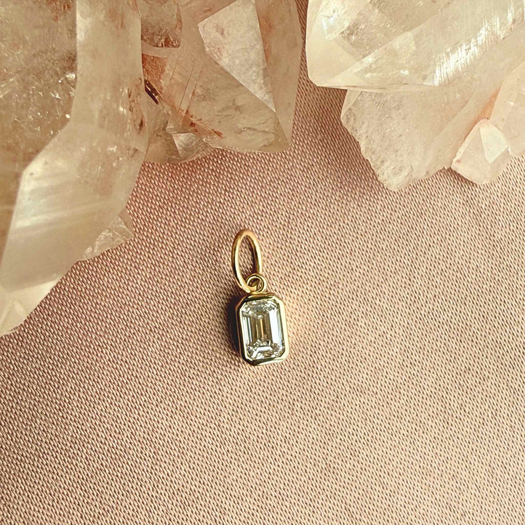 Close up of a bezel set lab grown diamond charm in 14K yellow gold showing the 5/8 carat stone by Camille Jewelry