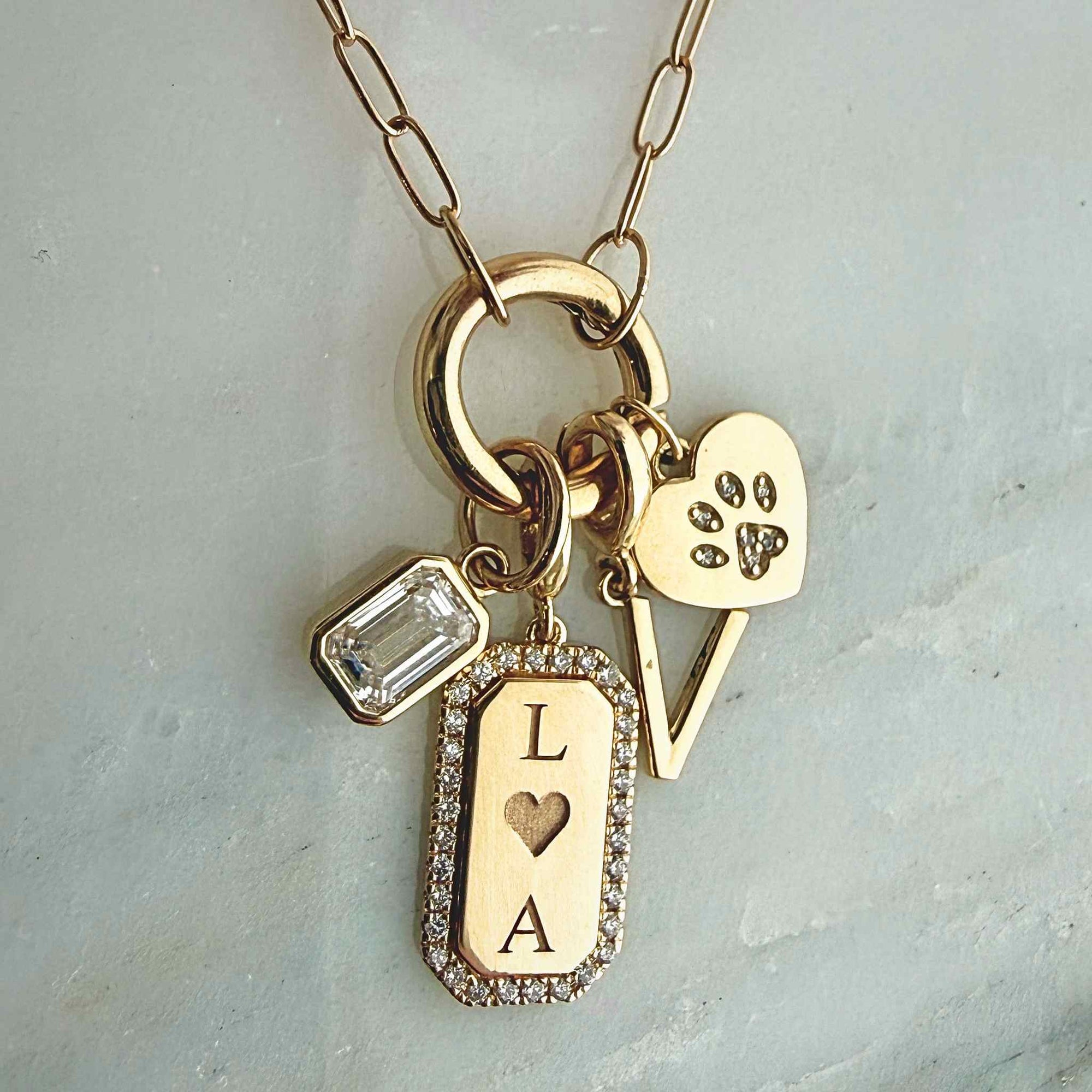 Lab grown diamond charm in 14K yellow gold styled on a charm holder necklace with other charms by Camille Jewelry