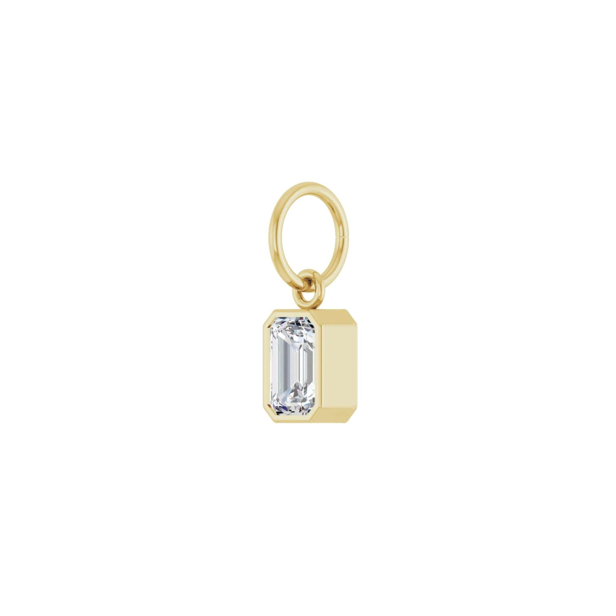 Lab grown diamond charm in 14K yellow gold with a bezel set stone on a white background angled view by Camille Jewelry