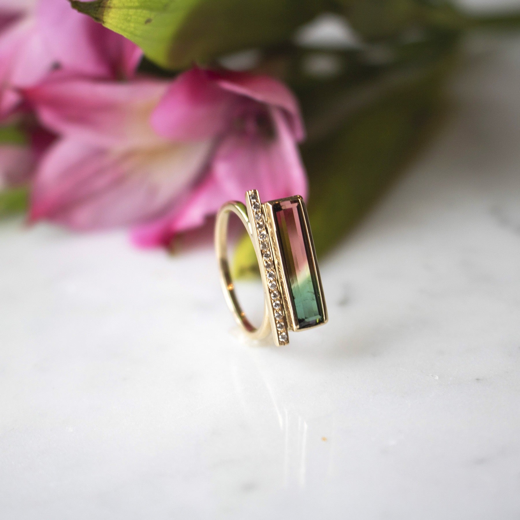 Diamond Bar Tourmaline Gemstone Ring with flower in the background - Camille Jewelry