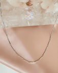 Magnetic convertible bar chain close up necklace in gold plated brass on a white background by Camille Jewelry