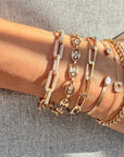 Stacked gold and diamond bracelets by Camille Jewelry worn on the wrist.